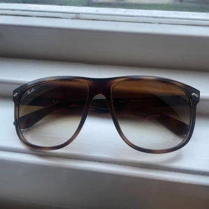 Ray-Ban solglasögon med bruntonade glas - Säljer mina äkta rayban boyfriend i storlek 60mm. Mycket bra skick utan några som helst defekter. Putsduk och fodral följer med. Hör av dig vid minsta lilla fråga!