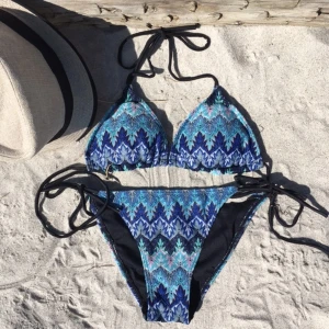 Blå bikini Design by Si - Säljer en super super snygg trekantsbikin från Design by si i storlek M. Den är köpt för 400 kr och är inte använd, endast överdelen är testad! Går att köpa bara överdelen för billigare, kontakta mig då! Säljer då den var för liten för mig, skulle säga att den passar någon med storlek XS-S.