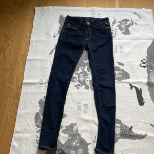 Mörkblå Replay jeansbyxor - Säljer ett par mörkblå skinny/ slim fit jeans från Replay med klassiska fem fickor och snygga kontrastsömmar. Byxorna har gylf med dragkedja och knapp samt läderpatch bak i midjan. Perfekta för dig som gillar en snygg passform👌