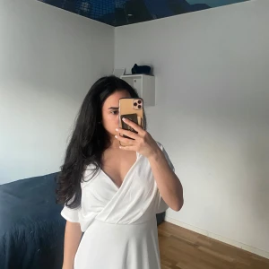 Vit studentklänning - Vit flowig studentklänning med v-ringning. Använd endast en gång ( inte till student) och helt nytt i skicket. Använde själv den för ett dop så den är också jättefin till sommaren 