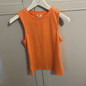Orange ribbad linnetopp från Object - Säljer en orange ribbad linnetopp från Object Toppen är ärmlös med rund halsringning och har en tight passform. Perfekt för varma dagar eller som layering-plagg.