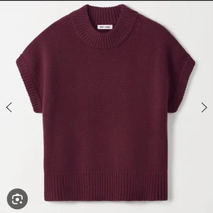 Vinröd stickad tröja från Soft Goat - Vinröd stickad tröja från Soft Goat i kashmir med korta ärmar och bred ribbad kant vid hals, ärmslut och nederkant. Perfekt att styla över en skjorta eller t-shirt för en chill men snygg look.