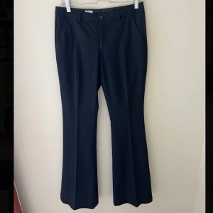 Låga svarta bootcut kostymbyxor Filippa K - Snygga lågmidjade svarta kostymbyxor från Filippa K i bootcut-modell.