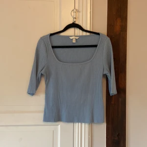 Ljusblå topp från H&M - Säljer en ljusblå ribbad topp från H&M med fyrkantig urringning. 