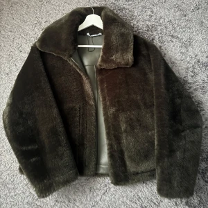 Mörkgrön pälsjacka - Säljer en snygg mörkgrön pälsjacka med bred krage och raka ärmar. Jackan är kortare i modellen och har två stora fickor framtill. Perfekt för dig som vill ha en mysig och trendig look under kyliga dagar. Min kamera för fram röda toner men dom finns ej i verkligheten, hackat är helt grön💗pris kan diskuteras!!