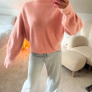 Ljusrosa stickad tröja från Weekday - Supermysig ljusrosa stickad tröja från Weekday med oversized passform och långa ärmar. Tröjan har en högre rund halsringning och är perfekt för lager-på-lager. Mjuk och fluffig känsla, passar perfekt till jeans eller kjol.