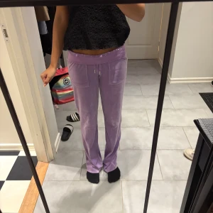 Ljuslila mjukisbyxor med snörning - Säljer ett par ljuslila juicy couture mjukisbyxor med raka ben och snörning i midjan. Byxorna har stora fickor fram och bak, samt en bekväm passform. Perfekta för en chill och avslappnad stil. Orginalpris 1100