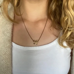 Guldigt halsband - Säljer ett Guldigt halsband med en rosett på💕