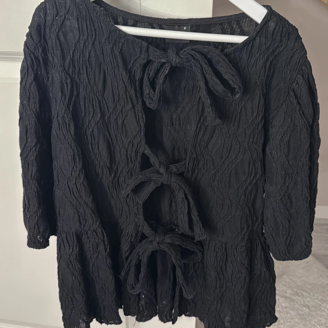Svart blus med knyt och struktur