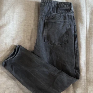 Svarta jeans från ASOS Design - Svarta jeans från ASOS Design med klassisk femficksmodell och raka ben. Jeansen är tillverkade i bomull och har en enkel, stilren look med normal passform. Perfekta för dig som gillar en clean och tidlös stil. Bara att höra av sig vid funderingar 😄