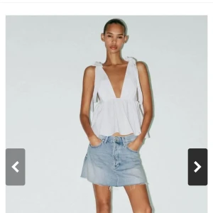 Vit slutsåld Zara topp med knytband och rosett - Supersöt vit linnetopp med djup v-ringning och breda axelband som knyts i rosetter. Toppen har en luftig, volangig passform och omlottkänsla. Perfekt till jeans eller kjol för en fräsch sommarlook. Slutsåld från Zara endast använd en gång men säljer pga att den ej passade. Lappen kvar. 