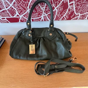 Marc Jacobs väska - Säljer min superfina mörkgröna Marc Jacobs väska med guldiga detaljer! Axelrem finns!❤️