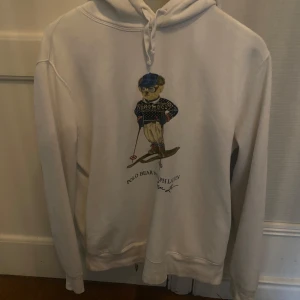 Vit hoodie Polo Bear Ralph Lauren M - Vit hoodie från Polo Ralph Lauren med ikoniskt Polo Bear-tryck på bröstet där björnen åker skidor. Pris kan diskuteras och byten likaså.