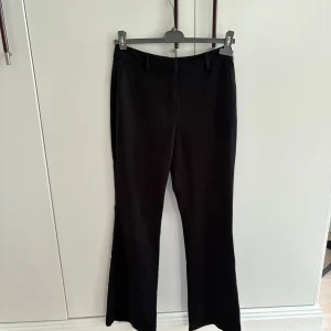 Svarta kostymbyxor - Kostymbyxor från NA-KD. De är använda ett fåtal gånger och är i väldigt fint skick! Innerbenslängden är 80 cm och byxorna har bootcut skärning. 