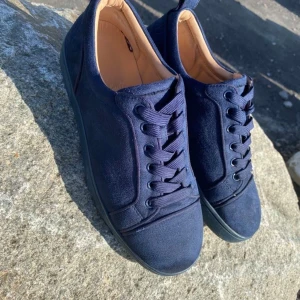 Mörkblå sneakers i mocka - Snygga mörkblå sneakers med ovandel i mjuk mocka och matchande snörning. Skorna har en klassisk rund tå och platt sula, perfekt för en stilren vardagslook. Insidan är fodrad i beige för extra komfort.