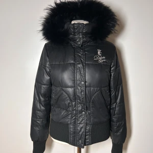 Jacka med pälskrage vintage 2000s y2k - Supersnygg vintage dunjacka med päls. (Ej äkta päls) Står ingen storlek men Passar S.  Väldigt fint skick.   Det enda märkbara är att det lossnat en bit av dragfliken. Man tänker inte på det och det syns inte, den funkar även att öppna och stänga dragkedjan med utmärkt. Kan skicka bild vid intresse.  Köp sker via köp nu, jag postar inom 24h. Kvar tills markerad såld  