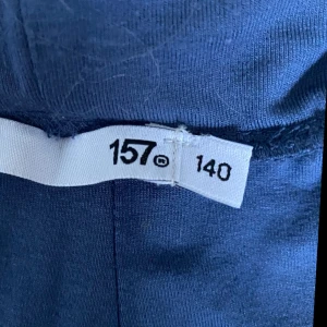 Mörkblå vida byxor i mjukt tyg - Säljer ett par mörkblå byxor med bred resår i midjan och vida ben. Byxorna är gjorda i ett mjukt och stretchigt material som känns skönt mot huden. Perfekta för en chill och avslappnad stil.