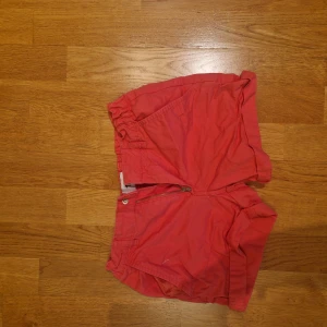 Rosa shorts med dragkedja - Snygga rosa shorts med klassisk passform och dragkedja framtill. De har fickor både fram och bak samt en midwaist design som gör dem bekväma och stilrena. Perfekta för varma dagar och passar till många olika looks.