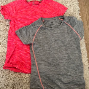 Två sportiga t-shirts från H&M - Säljer två tränings t-shirts från H&M. Ena är grå med rosa detaljer och den andra är rosa, båda med ett melerat mönster. De har korta ärmar och är gjorda i ett mjukt syntetmaterial som andas. Passformen är normal och de är riktigt bekväma.
