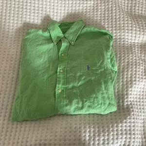 Raulf lauren skjorta  - Snygg grön skjorta från Ralph Lauren i slim fit-modell. Skjortan är tillverkad i linne och ikoniska broderade logotypen på bröstet. Perfekt för dig som vill ha en fräsch och stilren look. Inga skavanker inga fel, men bra pris😎