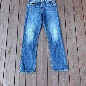 Blå jeans från Replay, rak modell - Säljer ett par klassiska blå jeans från Replay i rak passform. Jeansen har fem fickor, snygga slitningar och tydliga kontrastsömmar. Märkesdetaljer på fickan och bak. Perfekta för dig som gillar en tidlös denimlook.