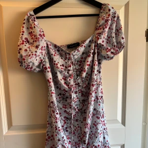 Blommig kortklänning med puffärmar - Superfin kortklänning köpt på Nelly.  Något liten i storlek, mer som en M.