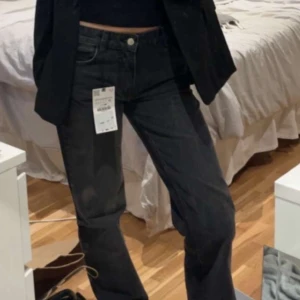 Svarta straight jeans - Säljer ett par svarta jeans med straight passform och mid midja. Klassisk femficksmodell med knapp och dragkedja framtill. Perfekta till vardags och lätta att matcha med olika toppar.