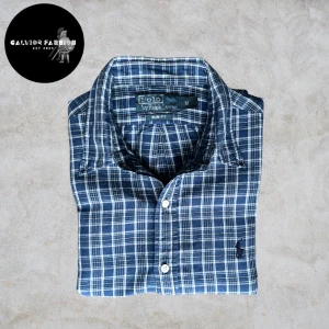 Ralph Lauren skjorta  - Säljer en blå-rutig skjorta från Polo Ralph Lauren i storlek M (Slim Fit). Tillverkad i mjuk bomull med en eventuell touch av linne som ger en luftig och skön känsla, perfekt för sommaren! Skjortan är i bra skick utan defekter eller fläckar                                                  ~                                                                                          Nypris runt 1500 kr | vårt pris: 495 kr. Hör av dig om du vill ha mått eller har frågor. Psst… alla följare får rabatt!