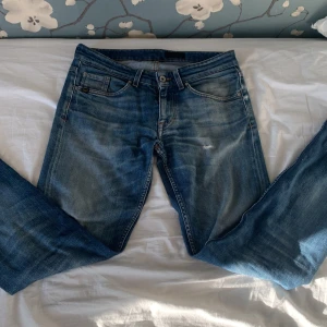 Blå jeans från Tiger of Sweden - Säljer ett par klassiska blå jeans från Tiger of Sweden. Jeansen har fem fickor, normal passform och raka ben. De är tillverkade i denim och har snygga slitningar framtill för en avslappnad look.Det är i storleken w29 L32 nypris är 1499 mitt pris 499 pris kan diskuteras.