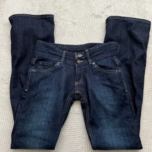 Mörkblåa jeans från Cross - Säljer ett par  mörkblå lågmidjade jeans från Cross som jag köpte från Plick men tyvärr passade inte mig. Midjemått: 36cm & innerbenet: 83cm.