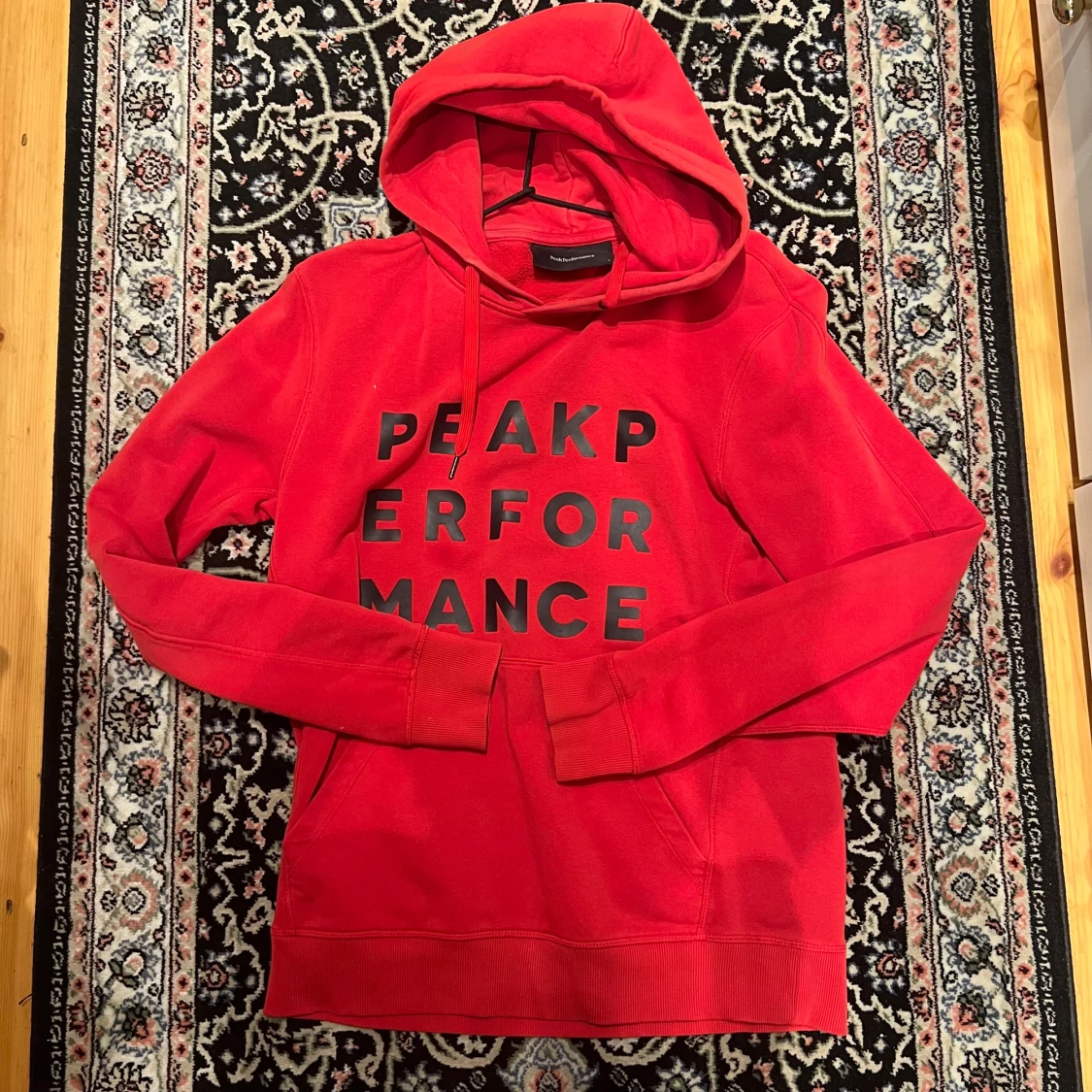 Röd hoodie från Peak Performance