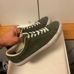 Gröna sneakers från Ralph Lauren - Snygga gröna sneakers från  Ralph Lauren i mocka med vita snören och vit sula. Klassisk låg modell med rund tå och diskret logga på sidan. Perfekta för en stilren vardagslook. Extremt skön och i nytt skick. Köptes för drygt 2000kr och har sedan dess endast används fåtal gånger. Storlek 43.