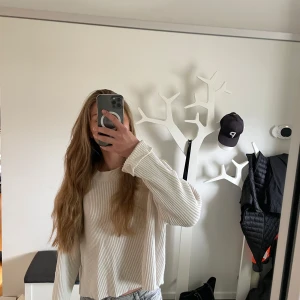 Vit ribbad stickad tröja från Bik Bok - Säljer en vit ribbad stickad tröja från Bik Bok i storlek XS. Tröjan har en croppad passform, rund halsringning och långa ärmar. Perfekt sista lager att dra på en kall sommarkväll. Enkel att matcha med jeans eller kjol.