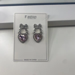 Hjärt örhängen - Super fina hjärtörhängen med en rosett över i silver. Hjärtat är i rosa💝 har aldrig använt de då jag fick hem de men insåg att jag beställt fel. Köpte från shein💞priset går att diskutera💓
