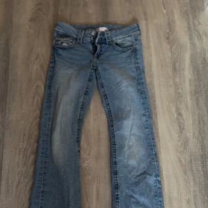 Blå jeans från Gina Tricot, stl 158 - Snygga blå jeans från Gina Tricot i storlek 158. Klassisk femficksmodell med dragkedja och dubbla knappar i midjan. Jeansen har en rak passform och är tillverkade i slitstarkt denimtyg med ljus tvätt och snygga detaljer.