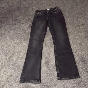 Svarta bootcut jeans Gina Tricot - Svarta jeans från Gina Tricot i bootcut-modell med snygga kontrastsömmar och klassiska fickor. Jeansen har en något utsvängd passform nertill och är tillverkade i mjukt denimtyg. Perfekta för dig som gillar en tidlös look med lite edge.