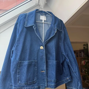 Mörkblå jeansjacka med stora fickor och knappar - ⭐️Intressekoll!!⭐️Supersnygg mörkblå jeansjacka från H&M med klassisk krage (twilljacka med krage), stora framfickor och knäppning med ljusa knappar💙. Boxig i modellen som gör att den sitter så snyggt! Den är helt slutsåld på hemsidan. Har aldrig använt den⭐️. Buda gärna på den, inte säker på om jag vill sälja 🥰.
