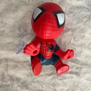 Spindelmannen Fönster/Glas Deklaration  - Bilderna visar en leksaksfigur av Spiderman med sugproppar, 
