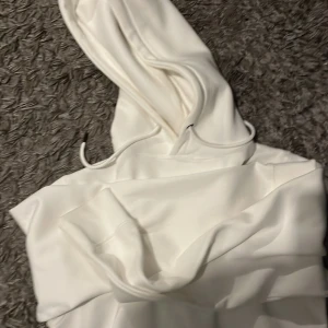 Vit hoodie med huva och snörning - Snygg vit hoodie med klassisk huva och snörning. Tröjan har en enkel och clean look, perfekt för dig som gillar stilrena plagg. Mjuk och skön, passar till många olika outfits.