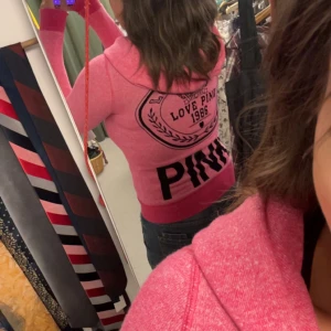 Rosa hoodie från Victoria's Secret PINK - Snygg rosa stickad hoodie från Victoria's Secret PINK med dragkedja, huva och fickor. Stor logga och tryck på ryggen samt mindre logga fram. Mjuk och skön, perfekt för chill eller skola. Långärmad.