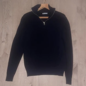 Mörkblå stickad half zip-tröja Zara - Mörkblå stickad tröja från Zara i storlek M. Tröjan har en snygg half zip-dragkedja och hög krage, perfekt för lager-på-lager. Ribbstickad struktur och långärmad modell som ger en clean och stilren look. Passar S