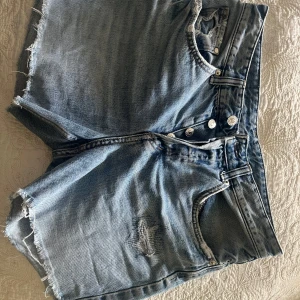Boyfriend jeansshorts från &Denim - Snygga boyfriend shorts i ljusblå denim från H&M. Modellen är lågmidjad med råa, fransiga benslut och slitningar både fram och bak. Klassisk femficksdesign med knappar. Perfekta för en chill sommarlook.