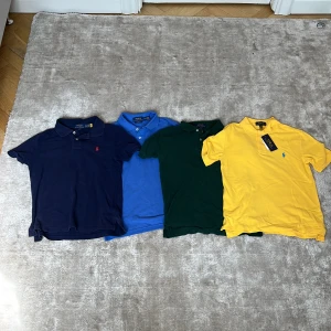 4-pack Polo Ralph Lauren pikétröjor - Fyra klassiska pikétröjor från Polo Ralph Lauren i färgerna marinblå, blå, grön och gul. Tröjorna har krage, knappar och broderad logga på bröstet. Perfekt för dig som gillar stilren och sportig look. Materialet är mjuk bomull och passformen varierar mellan slim och classic fit. Säljer även två vita också i strlk 10-12 och 14-16👍varje plagg säljer jag för 200kr👋💚
