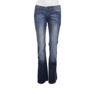 Blå bootcut jeans  - Snygga blå jeans med bootcut passform och coola broderade detaljer på bakfickorna. Jeansen har klassisk femficksdesign, låg midja. Midjemåttet 76