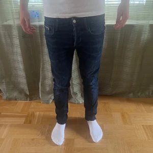 Mörkblå Replay jeans - Säljer ett par mörkblå slim fit jeans från Replay. Det står inte vilken modell de är då de är ganska gamla, men tror de är anbass eftersom dem sitter likadant. Modellen är 181 och väger 66, storlek W30 L32 men sitter som W30 L30 pga uppsydda. Skick 8/10 använda men inga defekter. Skriv vid frågor eller liknande!