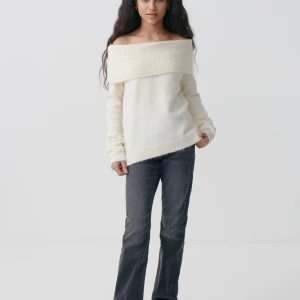 Offshoulder vit stickad tröja - Superfin offshoulder stickad tröja i vit färg med bred ribbad kant upptill. Tröjan har lång ärm och en loose passform som ger en chill vibe. Perfekt att styla med jeans för en enkel men snygg look.