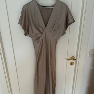 Champagnefärgad långklänning i satin - Elegant långklänning i champagnefärgad satin. Slutsåld klänning från Zara. 