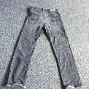 Replay grå jeans straight fit - Snygga grå jeans från Replay med klassisk femficksdesign och raka ben. Jeansen har en diskret tvättad look och tydliga sömmar vid fickorna. Passar dig som gillar en enkel men stilren vibe. Materialet är mjukt och följsamt jeans.  Storlek 158