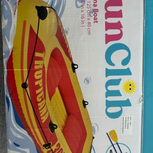En uppblåsbar båt - Detta är en uppblåsbar sunclub båt som är gul och röd den är 252cm x 125cm x 40cm. Det är en större model av den originalla sunclub båten denna har också säten i båten. Använd 1 gång.