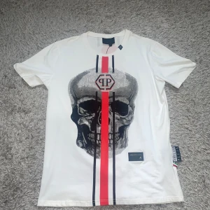NY PHILIPP PLEIN T-SHIRT VIT & RÖD STORLEK M  - Helt ny Philipp plein t-shirt. Aldrig använd den är väldigt fräsch och fin, passar båda könen. Storlek M.